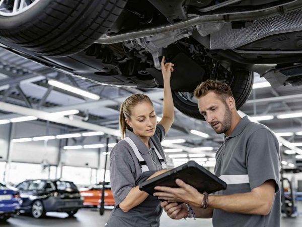 kobieta mechanik i mężczyzna mechanik diagnozują samochód BMW